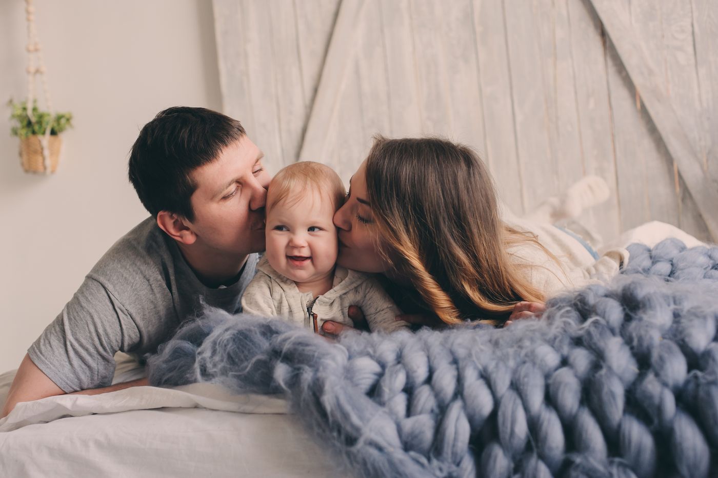Eltern küssen ihr Baby beim Fotoshooting